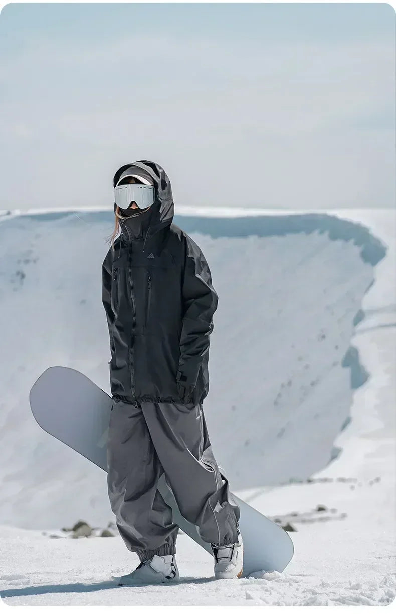 Model wearing Heronix grey baggy snowpants for skiing and snowboarding